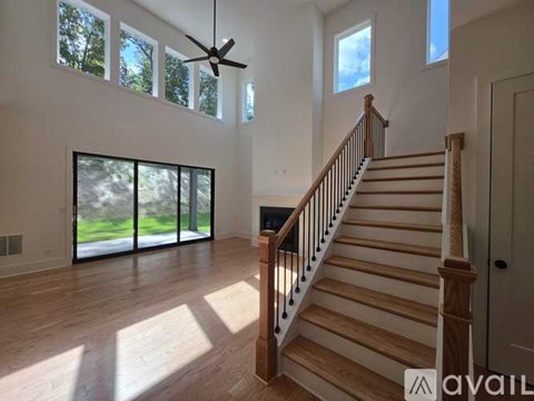 A spacious room with a staircase leading to the upper floor.