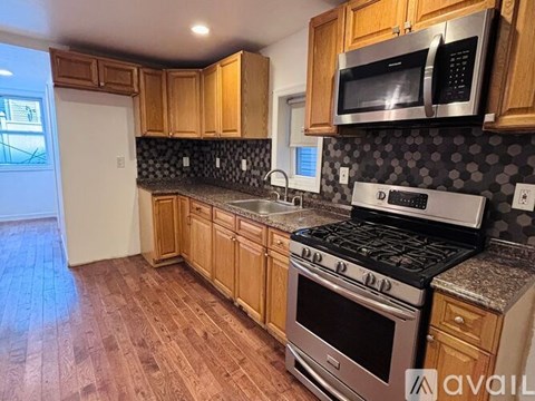 A kitchen with wooden cabinets and a stove top oven.