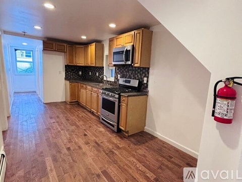 A kitchen with wooden cabinets and a black countertop.