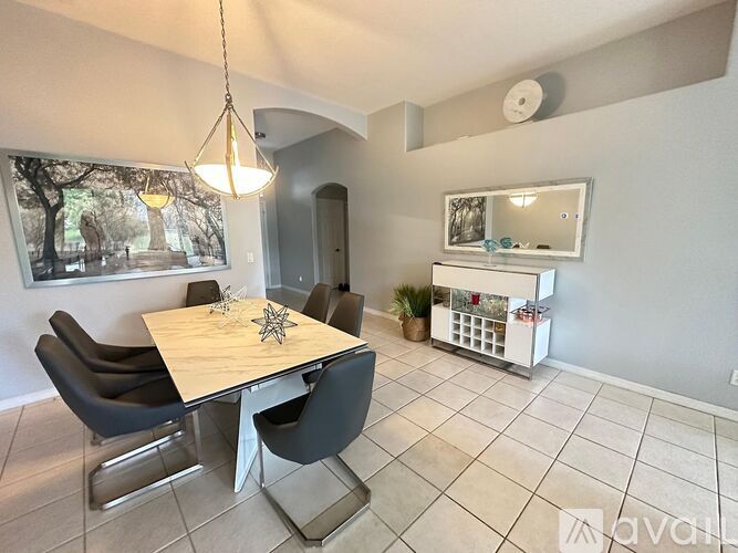 A dining room with a table and chairs.