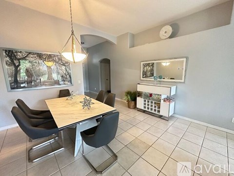 A dining room with a table and chairs.