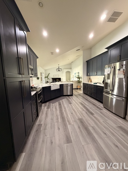 A modern kitchen with dark wood cabinets and stainless steel appliances.