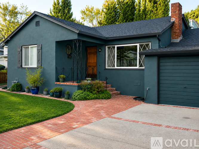 A house with a grey exterior and a red brick walkway.