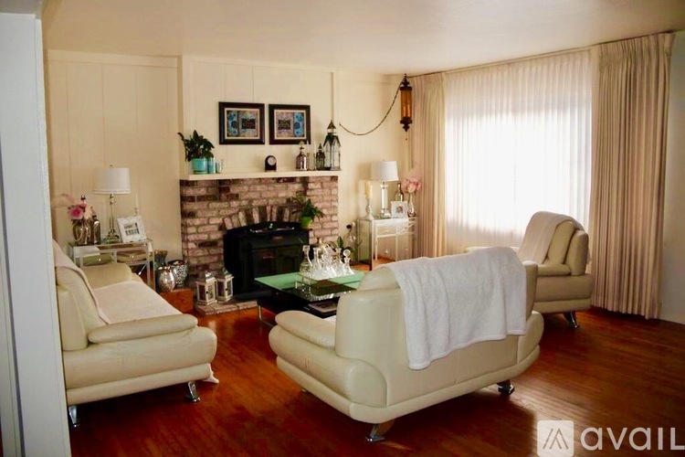 A living room with a fireplace, two chairs, and a sofa.