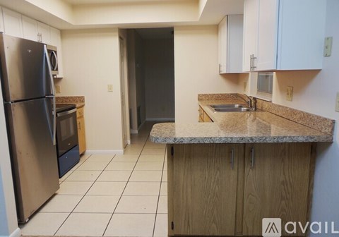 A kitchen with a refrigerator, oven, and sink.