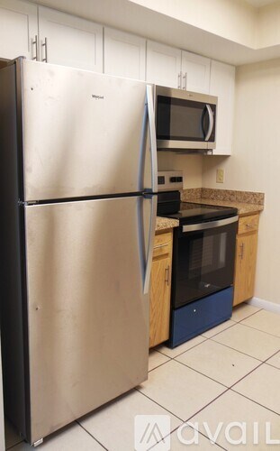 A kitchen with a stainless steel refrigerator and microwave.