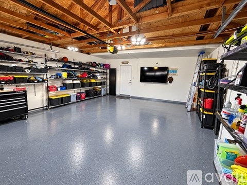 A spacious garage with a grey floor and wooden ceiling.
