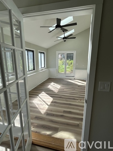 A room with a ceiling fan and a window.