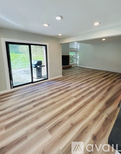 A room with wooden flooring and a sliding glass door.