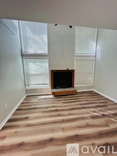 A living room with a fireplace and wooden flooring.