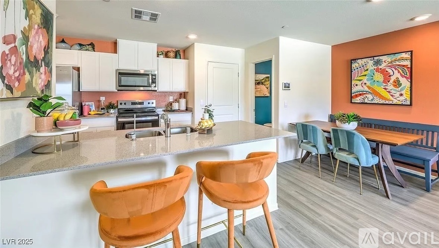 A kitchen with orange chairs and a white counter.
