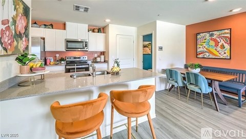 A kitchen with orange chairs and a white counter.
