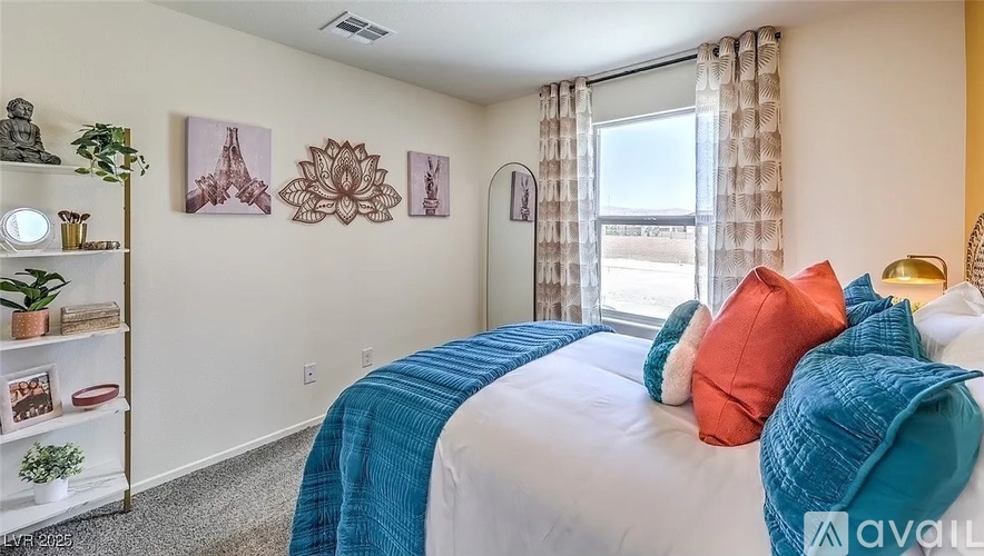 A bedroom with a bed covered in a blue and orange blanket.
