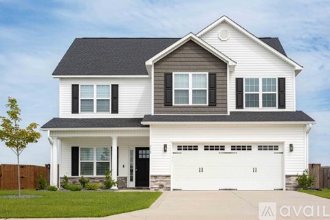A two-story house with a garage and a driveway.