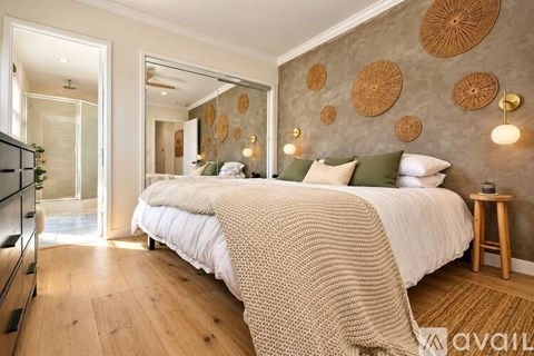 A bedroom with a large bed and a mirror on the wall.