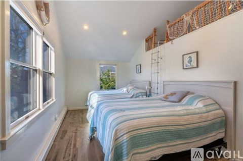 A bedroom with two beds and a window.