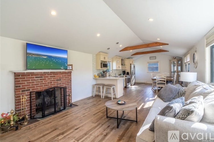 A living room with a fireplace and a flat screen TV mounted above it.