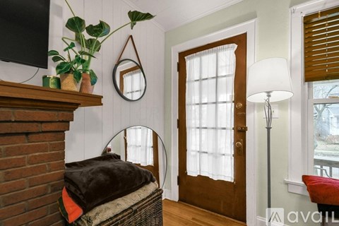 A room with a brick fireplace and a mirror above it.