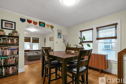 A dining room with a wooden table and chairs.
