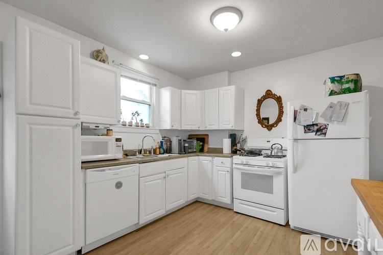 A kitchen with white cabinets and appliances.
