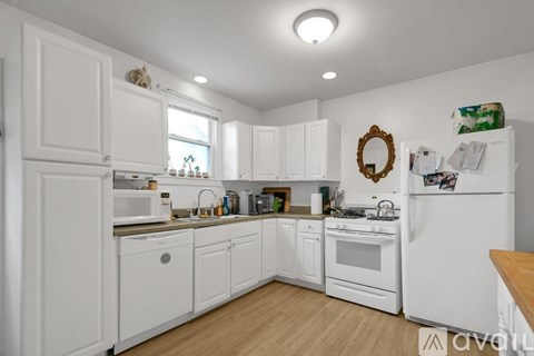 A kitchen with white cabinets and appliances.