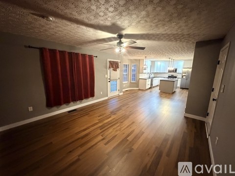 A room with wooden floors and a ceiling fan.