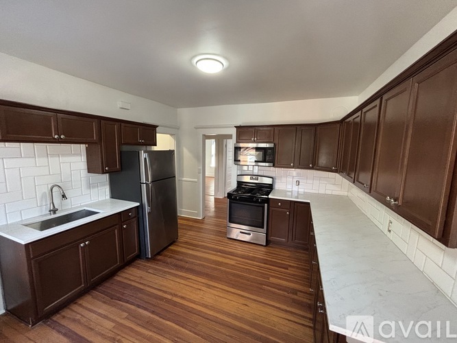A kitchen with dark wood cabinets and a white backsplash.