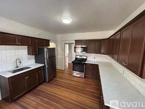A kitchen with dark wood cabinets and a white backsplash.