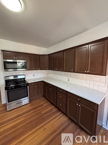 A kitchen with brown cabinets and a white counter.