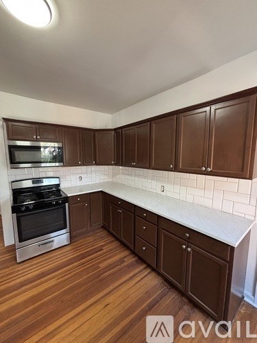 A kitchen with brown cabinets and a white counter.