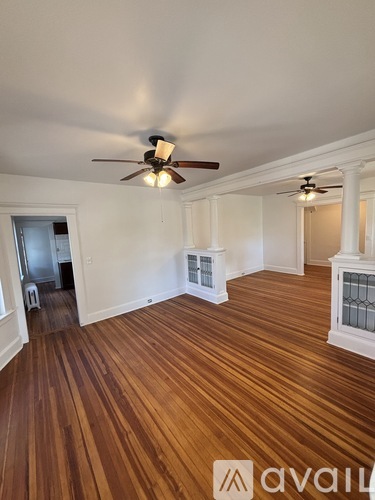 A room with wooden floors and a ceiling fan.