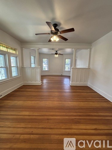 A room with wooden floors and a ceiling fan.