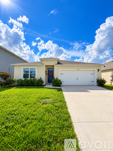 A house with a blue sky and clouds in the background.