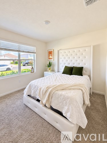 A bedroom with a large bed and a window overlooking a street.