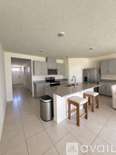 A kitchen with a granite countertop and stainless steel appliances.