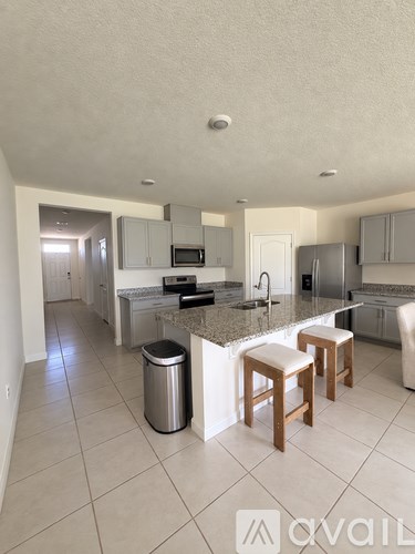 A kitchen with a granite countertop and stainless steel appliances.