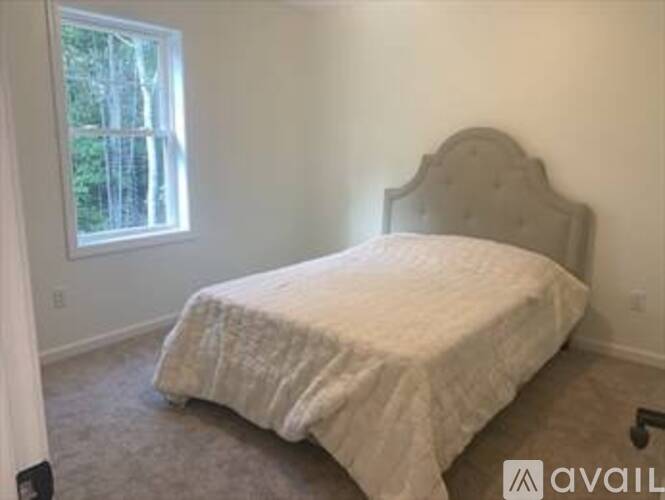 A bedroom with a bed and a window.
