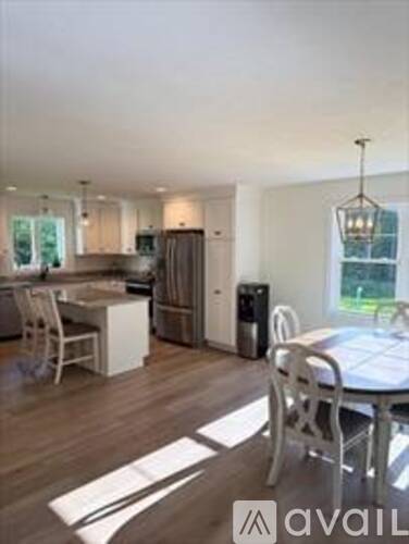 A kitchen with a dining table and chairs.