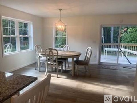 A dining room with a round table and chairs.