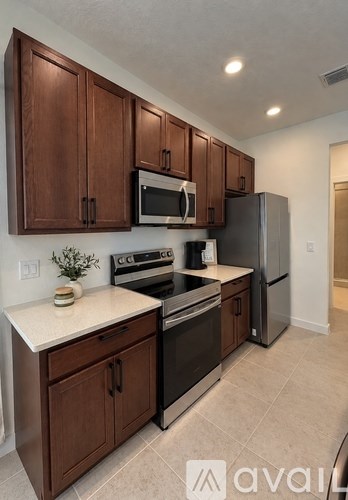 A kitchen with brown cabinets and stainless steel appliances.