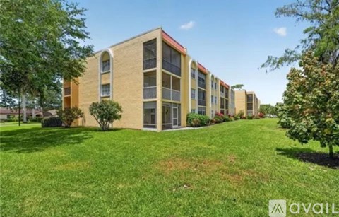 A row of apartment buildings with green lawns in front.