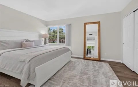 A bedroom with a large bed and a mirror on the door.