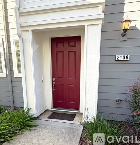 A red door with a white frame and a number 2139 on the wall.