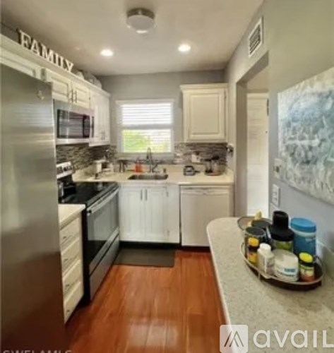 A kitchen with white cabinets and a black countertop.