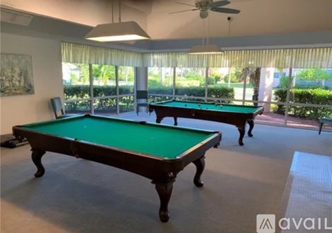 A pool table in a room with a ceiling fan.