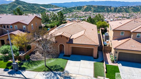 A house with a brown roof is surrounded by other houses.