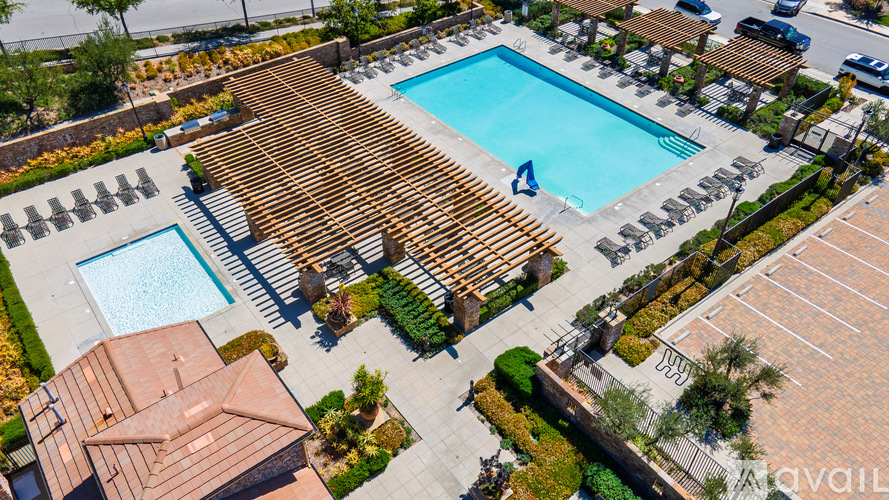 A swimming pool surrounded by a wooden deck and a small building.