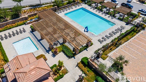 A swimming pool surrounded by a wooden deck and a small building.