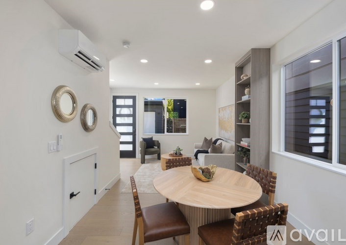 A modern dining room with a round table and chairs.