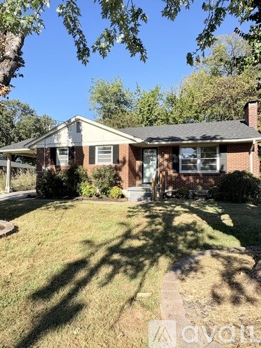 A house with a lawn and trees in the background.